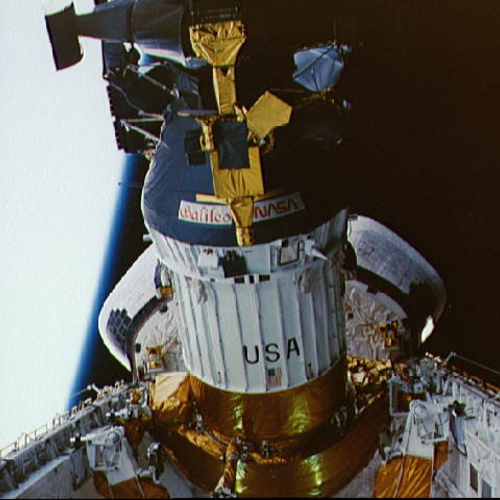 A large, cylindrical, white and gold spacecraft in orbit; the name "Galileo" is written on the spacecraft in an ornate, calligraphic font.
