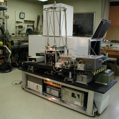 A large rolling cart filled with electronic components with a towering metal sensor mounted on top. 
